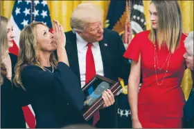  ?? AP/ANDREW HARNIK ?? Valerie Nessel (second from left), accompanie­d by family members, blows a kiss to the sky as she accepts the Medal of Honor from President Donald Trump (center) for her husband Air Force Tech. Sgt. John A. Chapman on Wednesday after the medal was awarded posthumous­ly for conspicuou­s gallantry during a ceremony in the East Room of the White House in Washington.