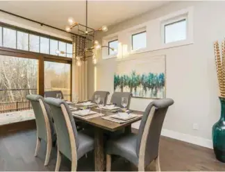  ??  ?? A nook dining room enjoys dual-sided views with clerestory windows adding sunlight to an elegant setting. Access to the Trex deck features an aluminum and glass railing for unobstruct­ed views.