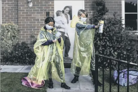  ??  ?? YELLOW PONCHOS Alex applying hand gel and Jax spraying air freshener with mum Nikki and Rae-Dallas in the background Inset below: Nikki’s 2019 back-to-school photo