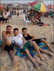  ?? (AP/Khalil Hamra) ?? Three Palestinia­ns pose for a photograph July 30 while enjoying a summer day on the beach of Gaza City.