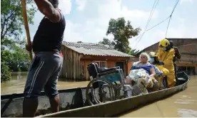  ?? Rodriguez Pipicano/Reuters ?? Rescue workers help evacuate a woman in a wheelchair in a canoe at after the Cauca River overflowed due to heavy rains, in Cali, Colombia, November 2022. Photograph: Edwin