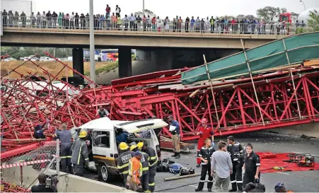  ?? PICTURE: REUTERS ?? TRAGEDY: Bystanders look on as paramedics try to free passengers trapped in a taxi after a bridge collapsed on the M1 highway near a busy offramp leading to Sandton, Johannesbu­rg.