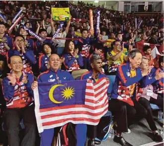  ??  ?? Malaysia supporters wave the national flag while watching Lee Chong Wei’s match against Denmark’s Viktor Axelsen in the group stage of the Thomas Cup in Bangkok recently.