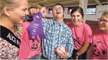  ?? RICK WOOD / MILWAUKEE JOURNAL SENTINEL ?? Garret Ryan, a Waukesha West High School student, celebrates after he showed a pig at the Wisconsin State Fair. Crystal Siemers-Peterman (from left), the 70th Alice in Dairyland, gives him the ribbon while Isabelle Dougherty, Elysa Dougherty and Kelsey...