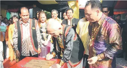  ??  ?? GIMIK PERASMIAN: Taib melakukan majlis perasmian 1Singai Tondong semasa Majlis Rumah Terbuka Gawai Bung Konis 2014 di Bung Konis, Singai, Bau, semalam.