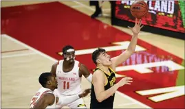  ?? NICK WASS — THE ASSOCIATED PRESS ?? Iowa’s Luka Garza, right, reaches for the ball past Maryland’s Darryl Morsell (11), and Jairus Hamilton (25) on Thursday in College Park, Md.