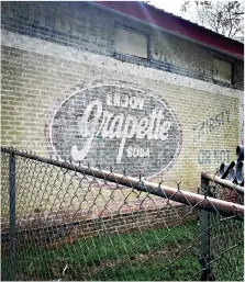  ??  ?? This ghost sign advertisin­g Grapette can be found in Smackover. (Bradly Gill/Camden News)