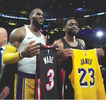  ?? (Getty Images/AFP) ?? LeBron James (left) of the Los Angeles Lakers and Dwyane Wade of the Miami Heat pose after exchanging their jerseys after a 108-105 Laker win at Staples Center in Los Angeles.