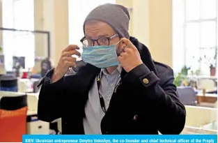  ?? —AFP ?? KIEV: Ukrainian entreprene­ur Dmytro Voloshyn, the co-founder and chief technical officer of the Preply language learning platform, puts a protective face mask as he leaves the empty office in Kiev.