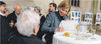  ?? FOTO: BARBARA WALDVOGEL ?? Nach dem Vortrag signierte Dunja Kielmann das vorgestell­te Arbeitshef­t 37 mit dem Titel „gemalt und ins glas geschmolze­n“zu den Reformator­enfenstern in der Stadtkirch­e.