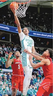  ?? AL GOLDIS/ASSOCIATED PRESS ?? Michigan State’s Marcus Bingham Jr. (30) goes up for a layup against Louisville’s Noah Locke, right, and Malik Williams (5) during Wednesday night’s game in East Lansing, Mich.