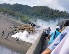  ?? WILBERT HERNÁNDEZ ?? Oficiales de la Fuerza Pública debieron usar gases lacrimógen­os para dispersar a manifestan­tes en un bloqueo en Caldera.