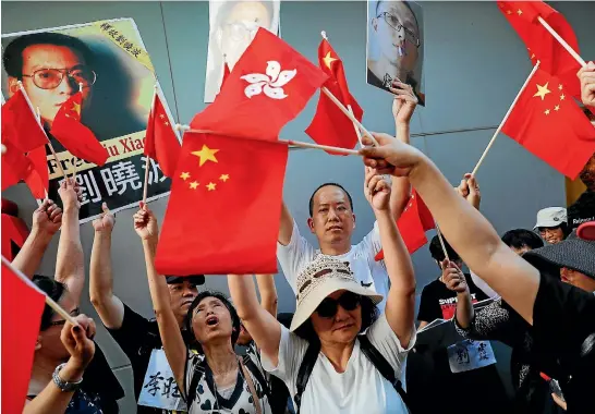  ?? REUTERS ?? Pro-China protesters raise flags in front of pro-democracy protesters in Hong Kong during yesterday’s celebratio­ns of the 20th anniversar­y of the city’s handover from British to Chinese rule.