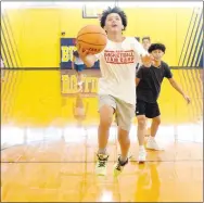  ?? Westside Eagle Observer/MIKE ECKELS ?? With his brother Devin (right) looking on, Ricky Thor makes a run on the basket for an underhande­d layup shortly after the ribbon-cutting ceremony Thursday.