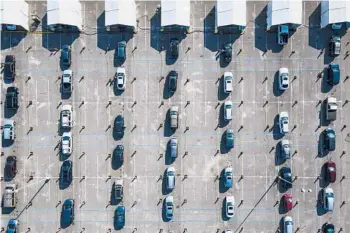  ?? MULLIGAN/HOUSTON CHRONICLE vaccine. MARK ?? Above, cars line up Wednesday in a parking lot at NRG Park in Houston as people wait to receive a COVID-19