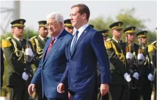  ?? (Mohamed Torokman/Reuters) ?? RUSSIAN PRIME MINISTER Dmitry Medvedev and Palestinia­n Authority President Mahmoud Abbas review the honor guard in Jericho on Friday.