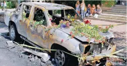  ?? PICTURE: GREGOR LEIGH ?? UPHEAVAL: Flowers were lain on a car set after it was set alight on campus yesterday.