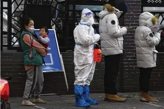  ?? ASSOCIATED PRESS ?? Residents line up for COVID-19 tests in Beijing on Saturday. Displays of public defiance have prompted authoritie­s in China’s western region to ease lockdowns in some places.