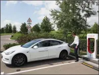  ?? Bloomberg News file photo ?? Igor Antarov, managing partner of the Moscow Tesla Club, charges a Model 3 last month in Moscow. Tesla stocks tumbled about 9 percent Friday after CEO Elon Musk said in a newspaper interview that stress may be getting the better of him.