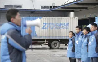  ?? — Reuters ?? Workers listen to their line manager, at a sorting centre of Zhongtong (ZTO) Express, Chaoyang District, Beijing.