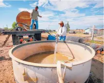  ?? ASSOCIATED PRESS ?? Richard Charley, right, and Melvin Jones deliver water to a ranch on the San Juan River on the Navajo Nation after the river was contaminat­ed with toxic wastewater from the Gold King Mine in 2015.