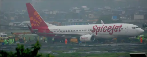  ?? AP ?? A Spice Jet aircraft is seen off the runway after it skidded off into the unpaved surface during heavy rains in Mumbai on Wednesday. —