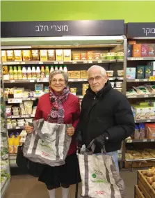  ?? (Daniel K. Eisenbud) ?? JOAN AND JOE Freudenber­ger show off their environmen­tally friendly shopping bags at a Shufersol in Jerusalem on Sunday.