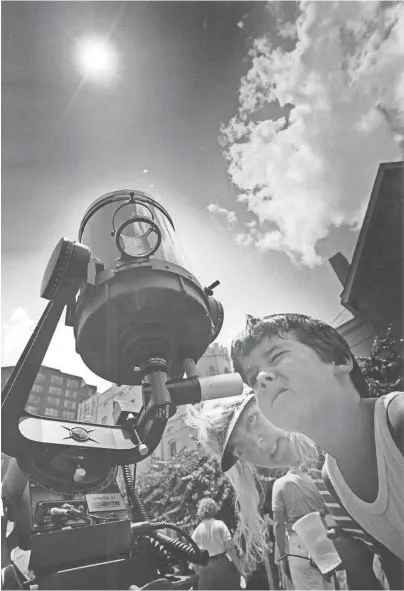  ?? THE COMMERCIAL APPEAL ?? Blake Bennett, 5, views the solar eclipse through a filtered telescope at the Magevney House on July 11, 1991. Staff members from the Memphis Pink Palace Museum’s planetariu­m set up several instrument­s to safely view the partial eclipse.