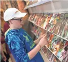  ?? 2018 PHOTO BY TY LOHR/THE EVENING SUN ?? Josiah Borwer, 12, looks through comic books at Kirby Comics.