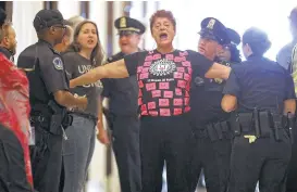  ?? Chip Somodevill­a / Getty Images ?? Demonstrat­ors are arrested by U.S. Capitol Police while protesting GOP health care legislatio­n outside the offices of Sen. Cory Gardner of Colorado.