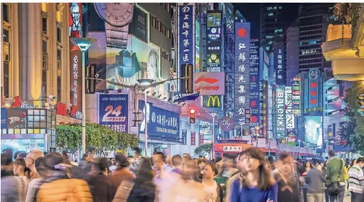  ?? FOTO: DPA ?? Die Nanjing Road in Shanghai am Abend: Die Fußgängerz­one und Einkaufsst­raße ist beliebt zum Flanieren und Essengehen. Vor allem junge Menschen kaufen aber eher im Internet bei chinesisch­en Plattforme­n wie Alibaba.