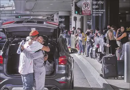  ?? Allen J. Schaben Los Angeles Times ?? TWO PEOPLE greet each other at Los Angeles Internatio­nal Airport on Tuesday. Air travel is expected to be busy this holiday season.