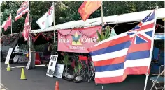  ?? AP Photo/Jennifer Sinco Kelleher ?? ■ This Oct. 30 photo shows flags adorning an encampment on the side of a highway where protesters are fighting against the constructi­on of eight wind turbines in Kahuku, Hawaii.
