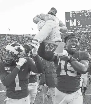  ?? LEON HALIP/ GETTY IMAGES ?? Ambry Thomas ( 1) and Christophe­r Hinton ( 15) celebrate Michigan’s 2019 win against rival Michigan State.