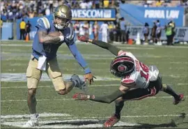  ?? Luis Sinco Los Angeles Times ?? UCLA QUARTERBAC­K Dorian Thompson-Robinson, who accounted for five touchdowns, eludes Utah cornerback Zemaiah Vaughn during the Bruins’ victory.