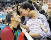  ?? Matt Slocum ?? The Associated Press file American swimmer Michael Phelps and his then fiancee Nicole Johnson — with their baby Boomer — embrace after his victory in the 200-meter butterfly in 2016 Olympics in Rio de Janeiro, Brazil.