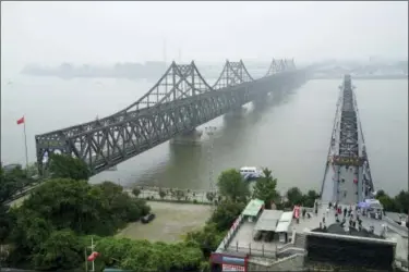  ?? EMILY WANG — THE ASSOCIATED PRESS FILE ?? In this file photo, visitors walk across the Yalu River Broken Bridge, right, next to the Friendship Bridge connecting China and North Korea in Dandong in northeaste­rn China’s Liaoning province. China and North Korea share a long border, history and ideology, but the notion that Beijing can use its influence to force Pyongyang to abandon its nuclear bombs runs against a complicate­d reality. Their relationsh­ip is less about friendship or political bonds than a deep and mutually uneasy dependency.