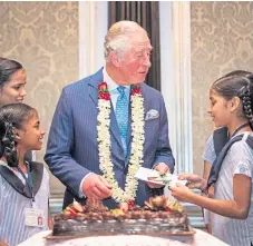  ?? Picture: PA. ?? The Prince of Wales receives a birthday card and cake from schoolchil­dren during a British Asian Trust reception in Mumbai, India.