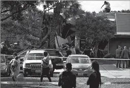  ?? JON SHAPLEY/HOUSTON CHRONICLE ?? Authoritie­s investigat­e the scene of a helicopter crash early Saturday at an apartment complex in Houston. One officer on board was killed, while a second was injured.