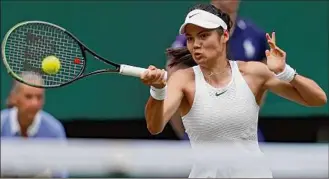  ?? Adrian Dennis / Getty Images ?? Britain's Emma Raducanu returns against Romania's Sorana Cirstea during their third-round match at Wimbledon. Raducanu won in straight sets, 6-3, 7-5.
