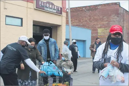  ?? LYRIC AQUINO — THE MORNING JOURNAL ?? Members of Men of Courage pass out literature, masks, snacks and water bottles to Fligner’s patrons on Oct. 24during an outreach event.