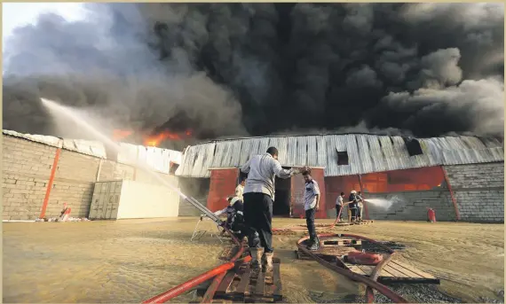  ??  ?? Firefighte­rs try to control a blaze engulfing a warehouse full of cooking fuel and food belonging to the World Food Programme in Hodeidah, Yemen, yesterday