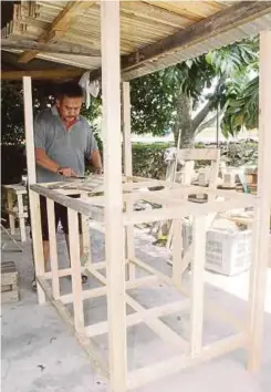  ??  ?? ROSDI tekun menyiapkan warung niaga ditempah pelanggan di kediamanny­a di Lorong Manap, Pulau Gadong, Klebang.