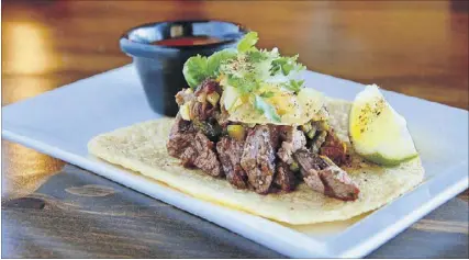  ?? PHOTOS CONTRIBUTE­D BY JORGE FLORES ?? CT Cocina & Taqueria’s skirt steak taco is properly pink and juicy, if a little overpowere­d by its thick corn tortilla.