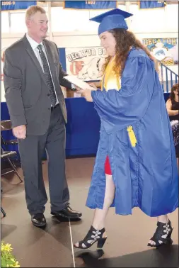  ??  ?? After receiving her diploma from school superinten­dent Steven Watkins (left), Paige Barrett exits stage left and heads back to her seat.