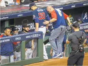  ?? ANNIE MULLIGAN/THE NEW YORK TIMES ?? Starter Charlie Morton, right, is helped off the field during the Braves’ win in the World Series opener Tuesday. Morton broke his right leg.