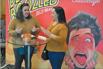  ?? PHOTO BY RICHARD BAMMER — THE REPORTER ?? Megan Patton, 33, of Suisun City, and longtime friend Kathleen Wise, 31, of Los Angeles, taste test one of five new hot Jelly Belly candy flavors — sriracha, jalapeno, cayenne, habanero, and Carolina Reaper — during the BeanBoozle­d Fiery Five Challenge at the Jelly Belly factory in Fairfield. The new jelly beans will be available for sale beginning in January.