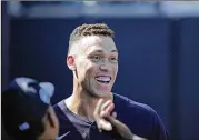  ?? DAVID J. PHILLIP/AP ?? Yankees star outfielder Aaron Judge, the reigning AL MVP, smiles in the dugout Monday during the team’s first full-squad spring training workout.