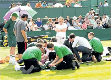  ?? DAVID RAMOS/GETTY IMAGES ?? Bethanie Mattek-Sands receives treatment from the medical team before retiring from her second-round match Thursday at Wimbledon.