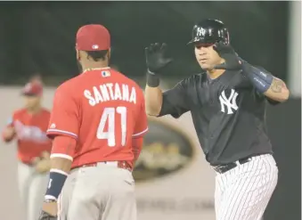  ?? AP ?? Gary Sánchez celebra en primera tras pegar un hit. De espalda, Carlos Santana (41).